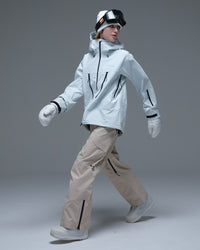 Full-body action view of a model wearing the ice blue Nobaday Women’s Snowshield Pro 3L Snow Jacket with beige snow pants