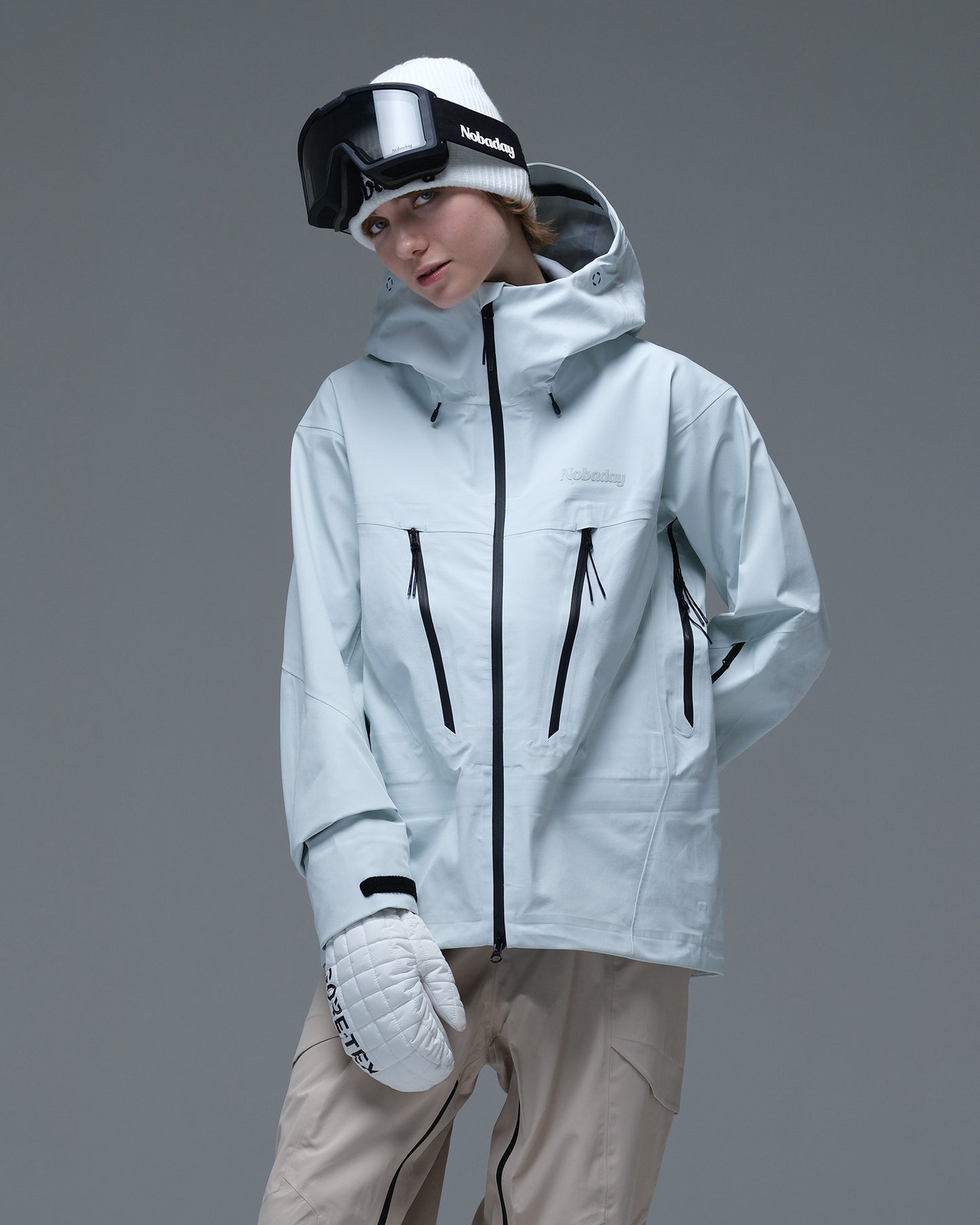 Half-body action view of a model wearing the ice blue Nobaday Women’s Snowshield Pro 3L Snow Jacket with black waterproof zippers