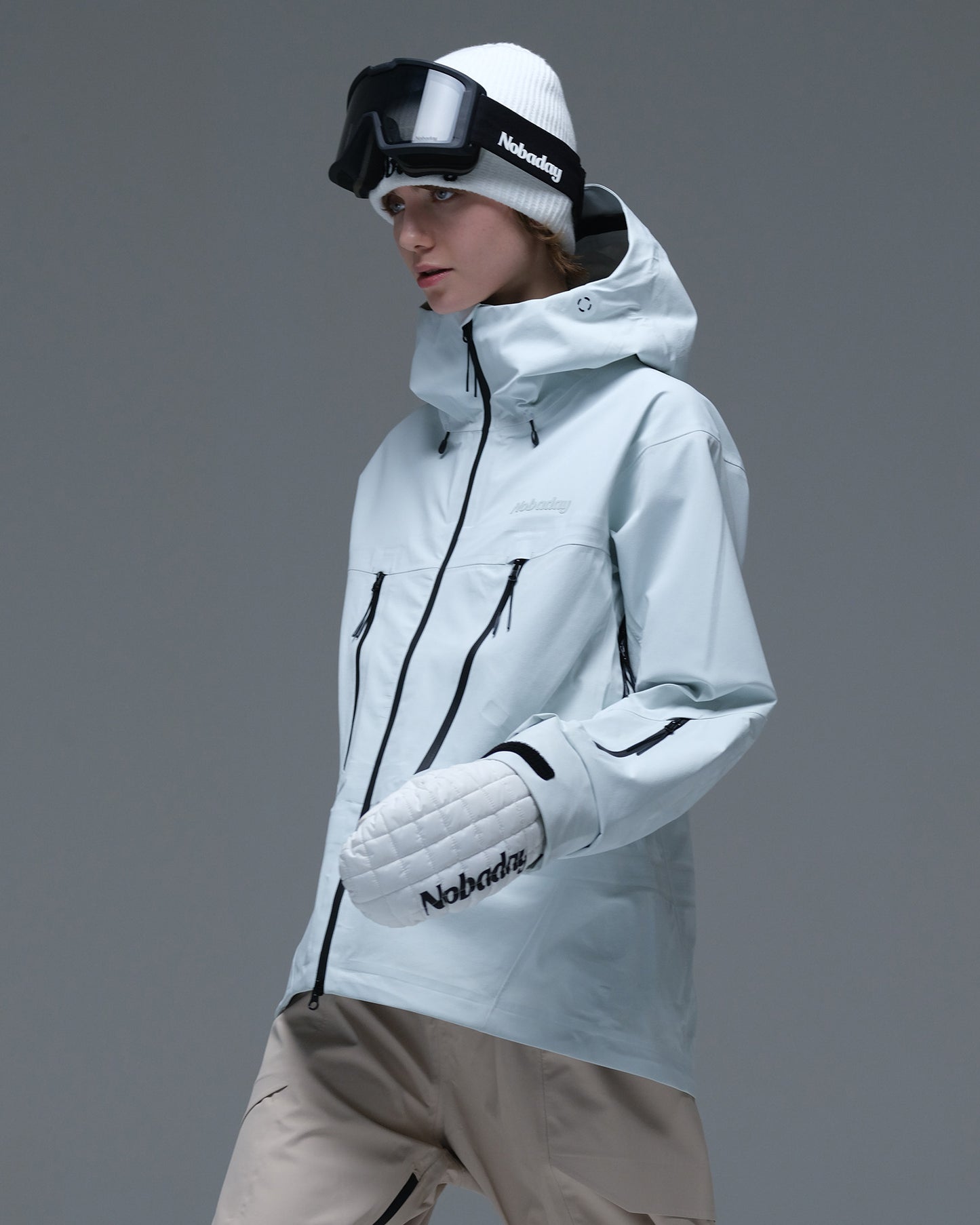 Side view of the ice blue Nobaday Women’s Snowshield Pro 3L Snow Jacket with a high collar, hood and sleeve pocket