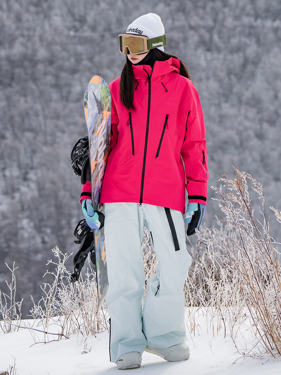 Female snowboarder wearing the NOBADAY Women's SnowShield Pro 3L red waterproof snow jacket while holding a snowboard on a snowy mountain